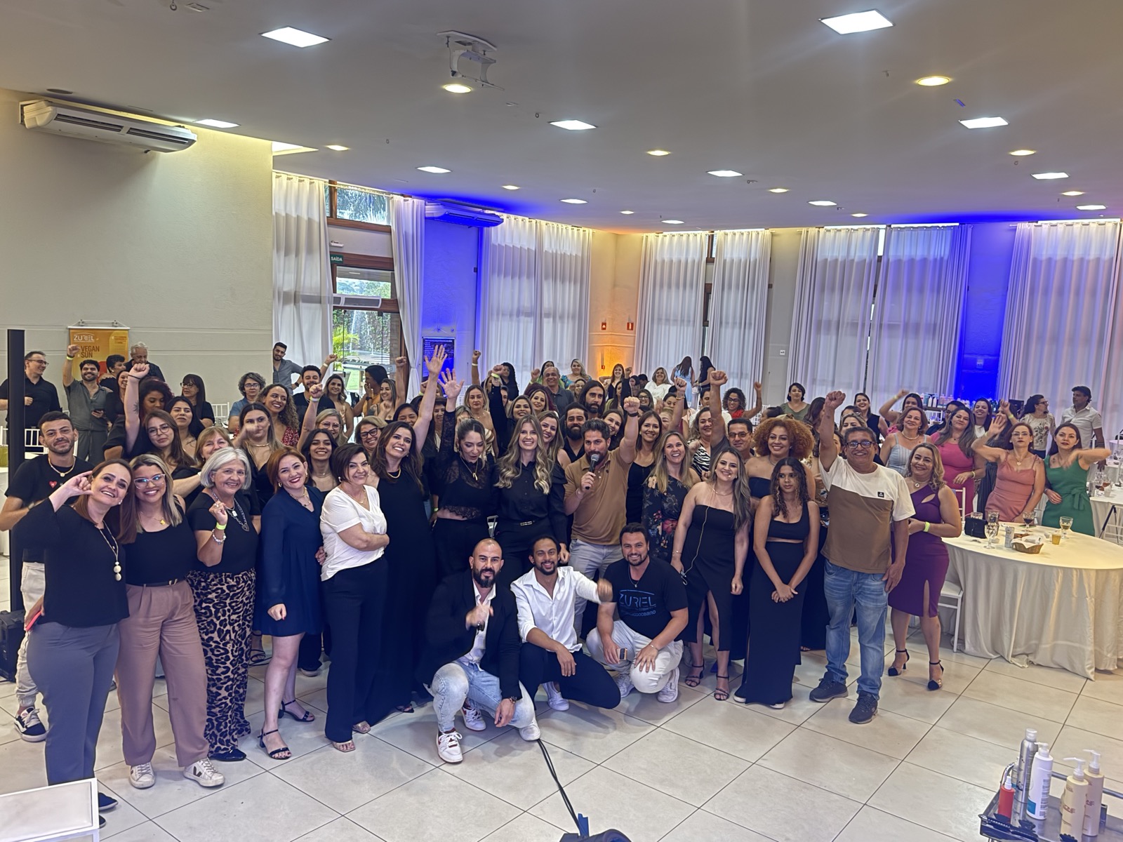 Jhon ao centro de evento presencial com a turma de mentorados